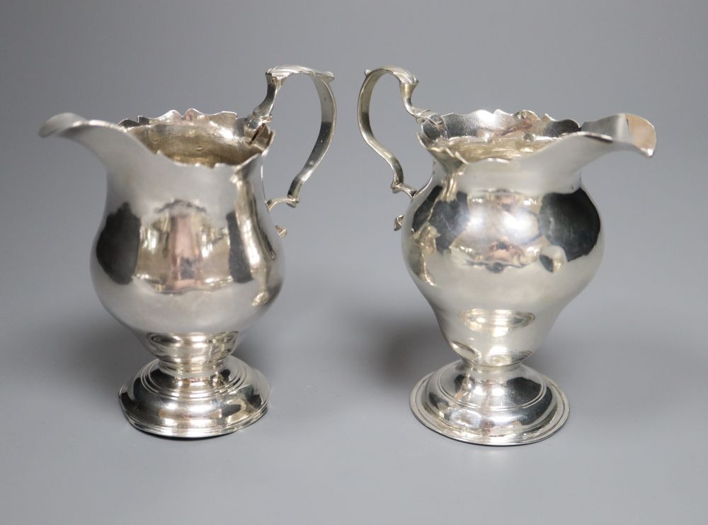 A late George II silver inverted pear shaped cream jug, Stamp & Baker, London, 1759 & one other cream jug.